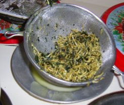 strained herbs in sieve